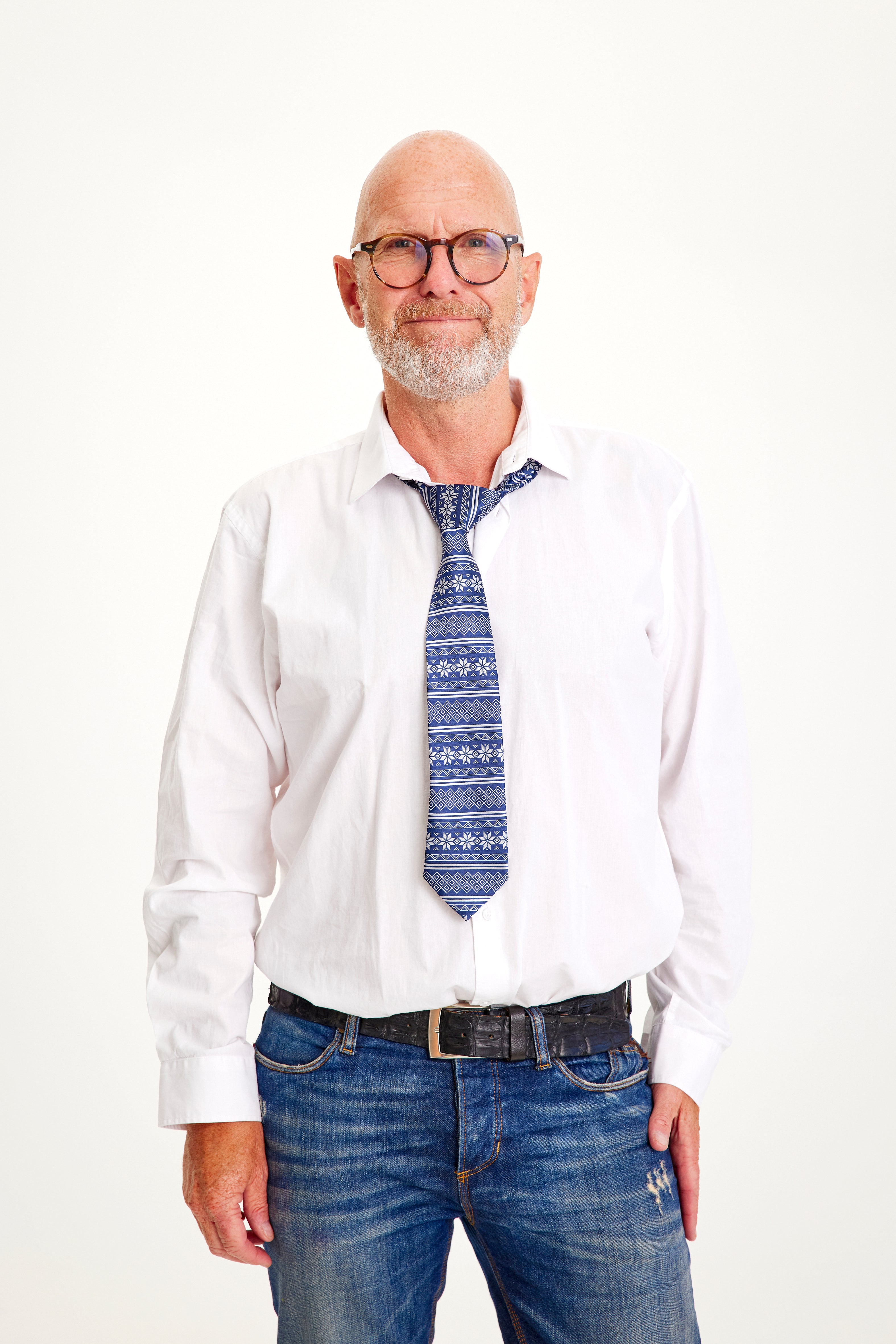 En smilende mand iført et blå juleslips og hvid skjorte.