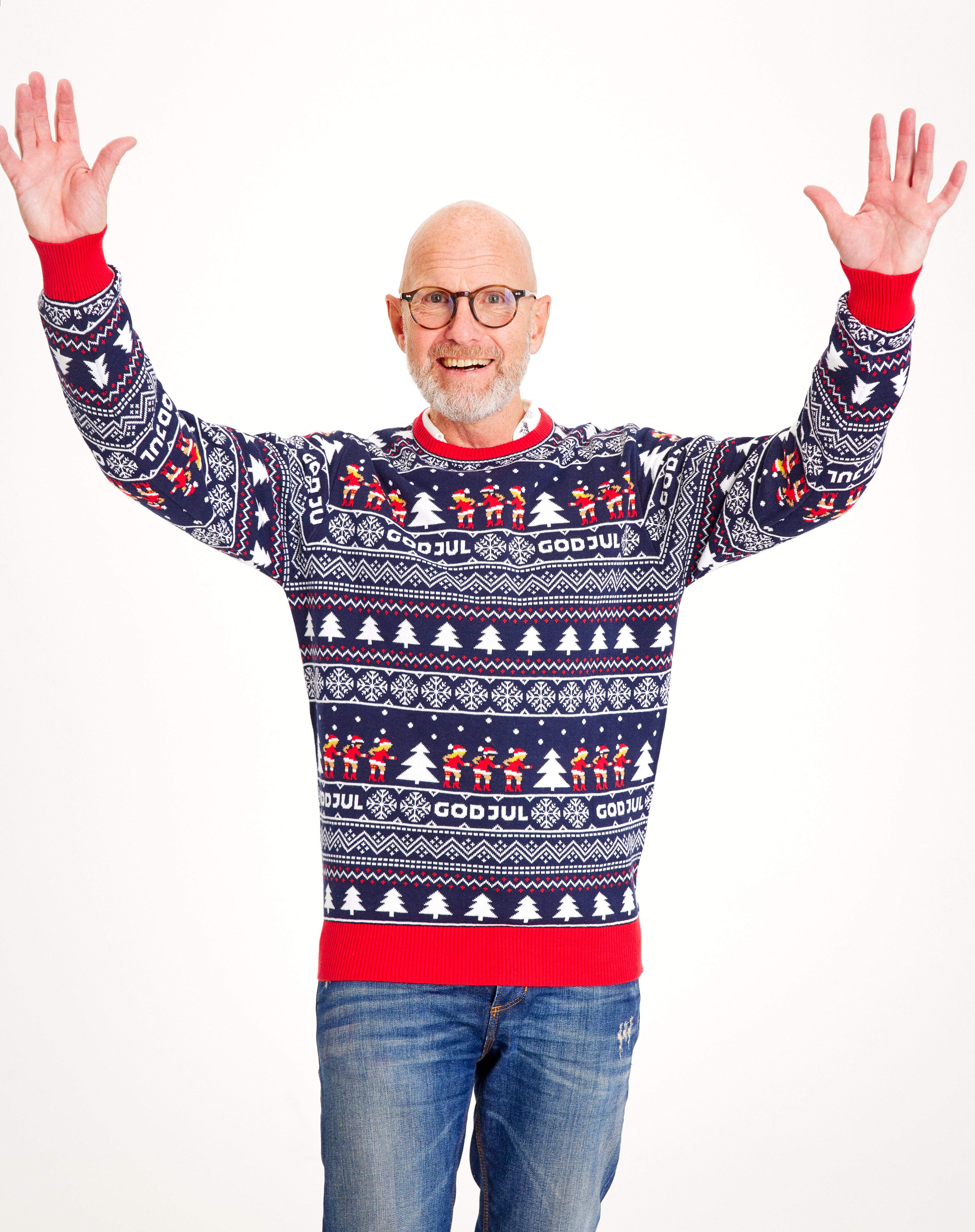 En mand iført en blå julesweater med julemønster.
