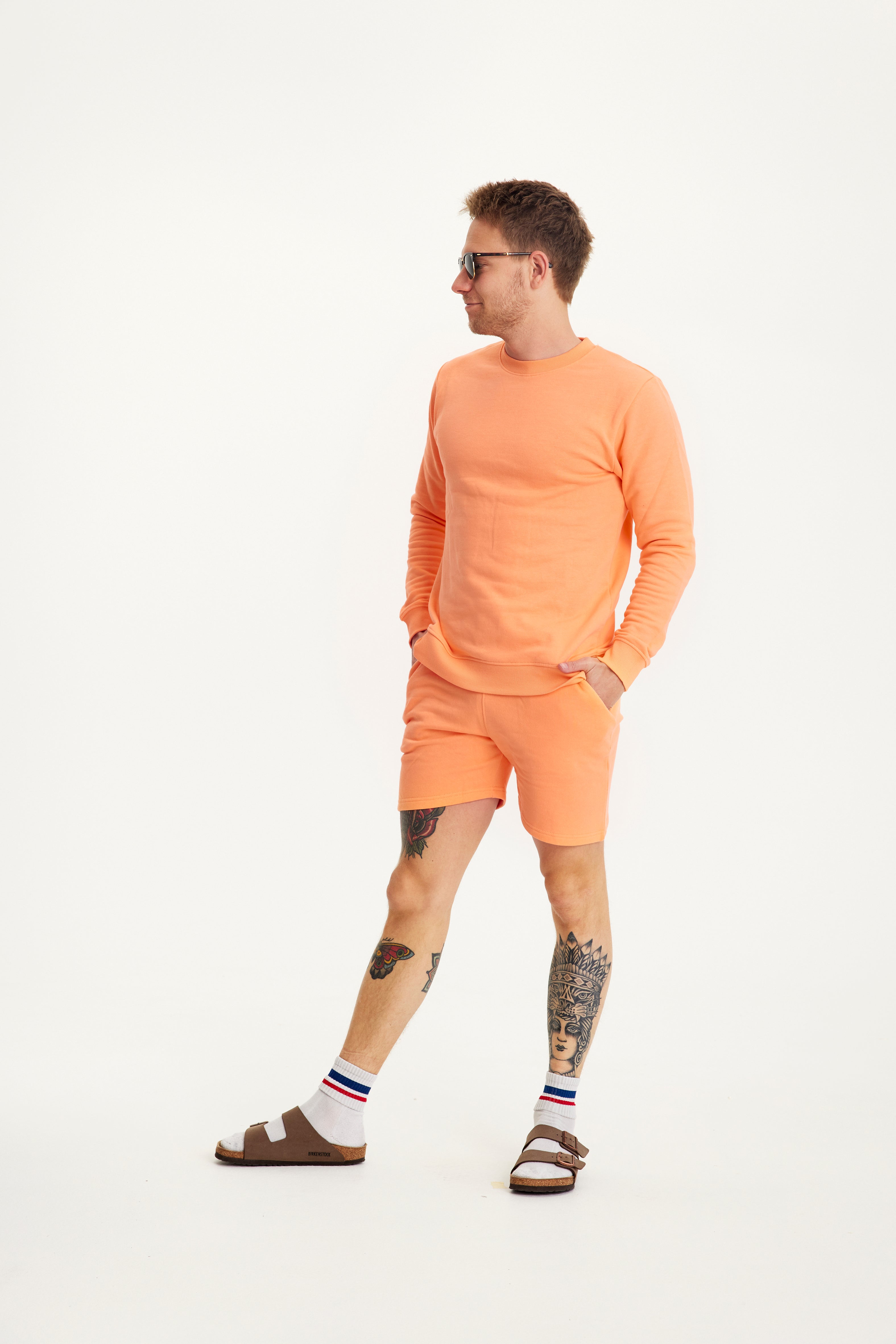 En mand kigger til siden og er iført et sommersæt.