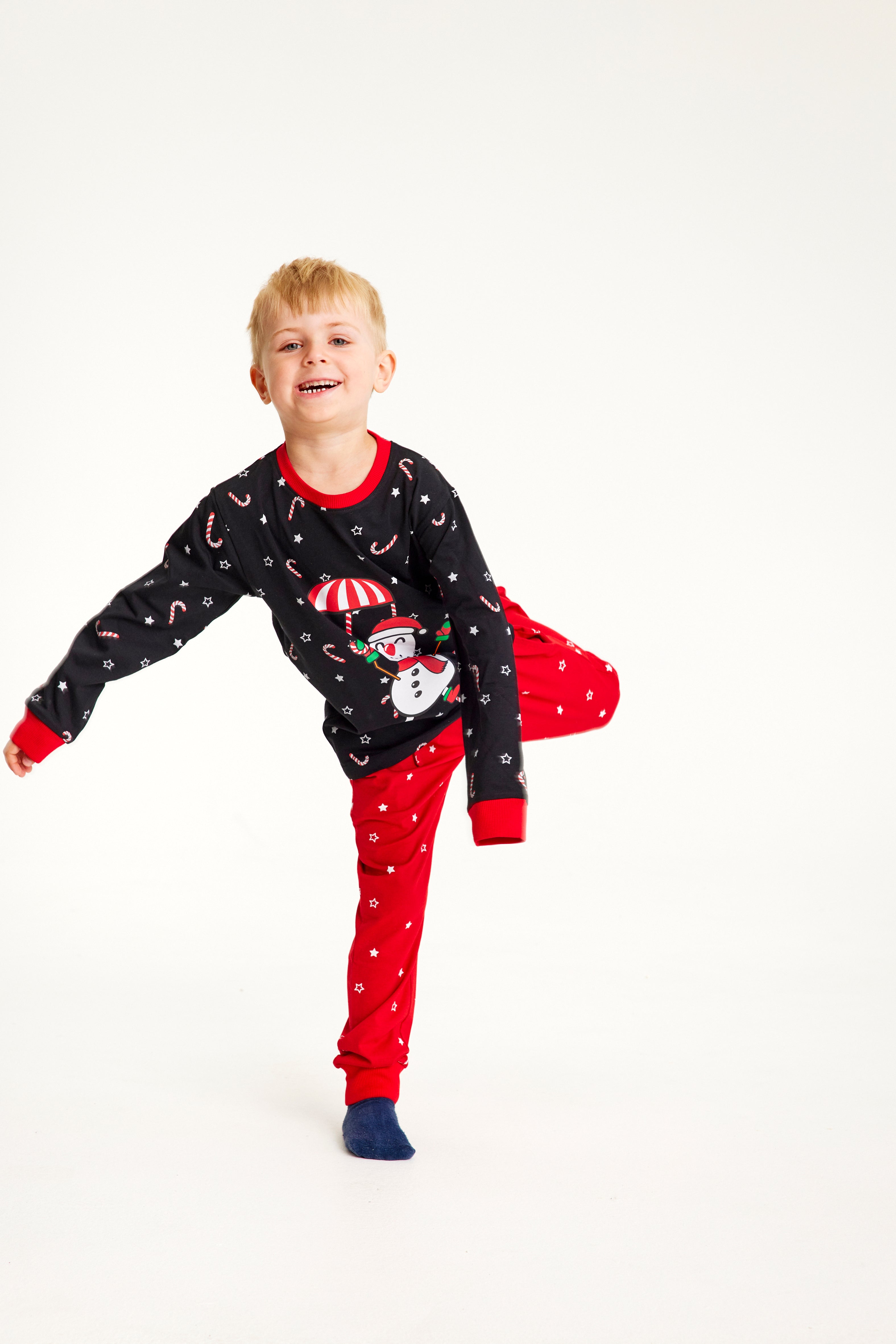 En legende dreng iført sorte og røde julepyjamas.