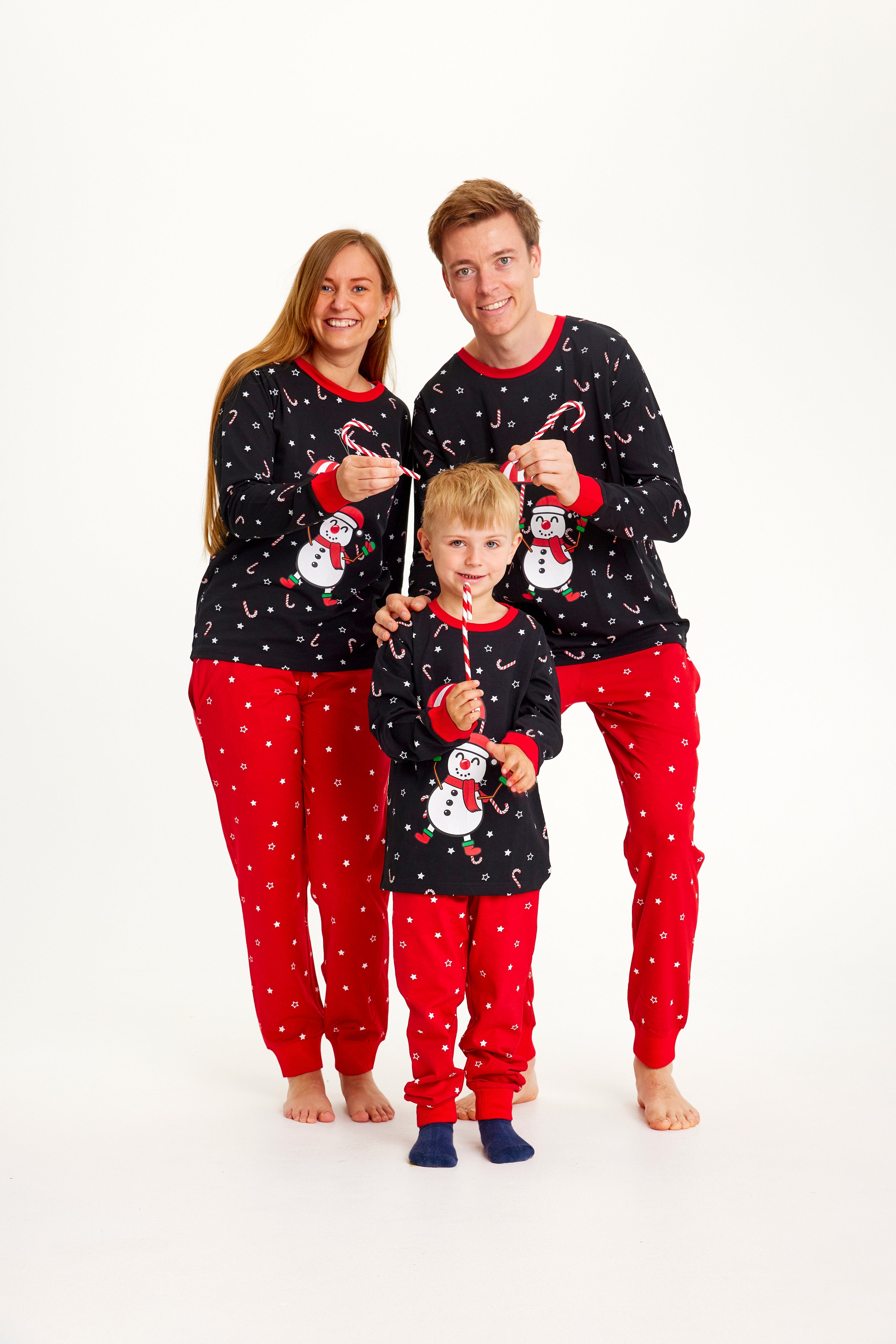 En familie med sukkerstokke iført julepyjamas.