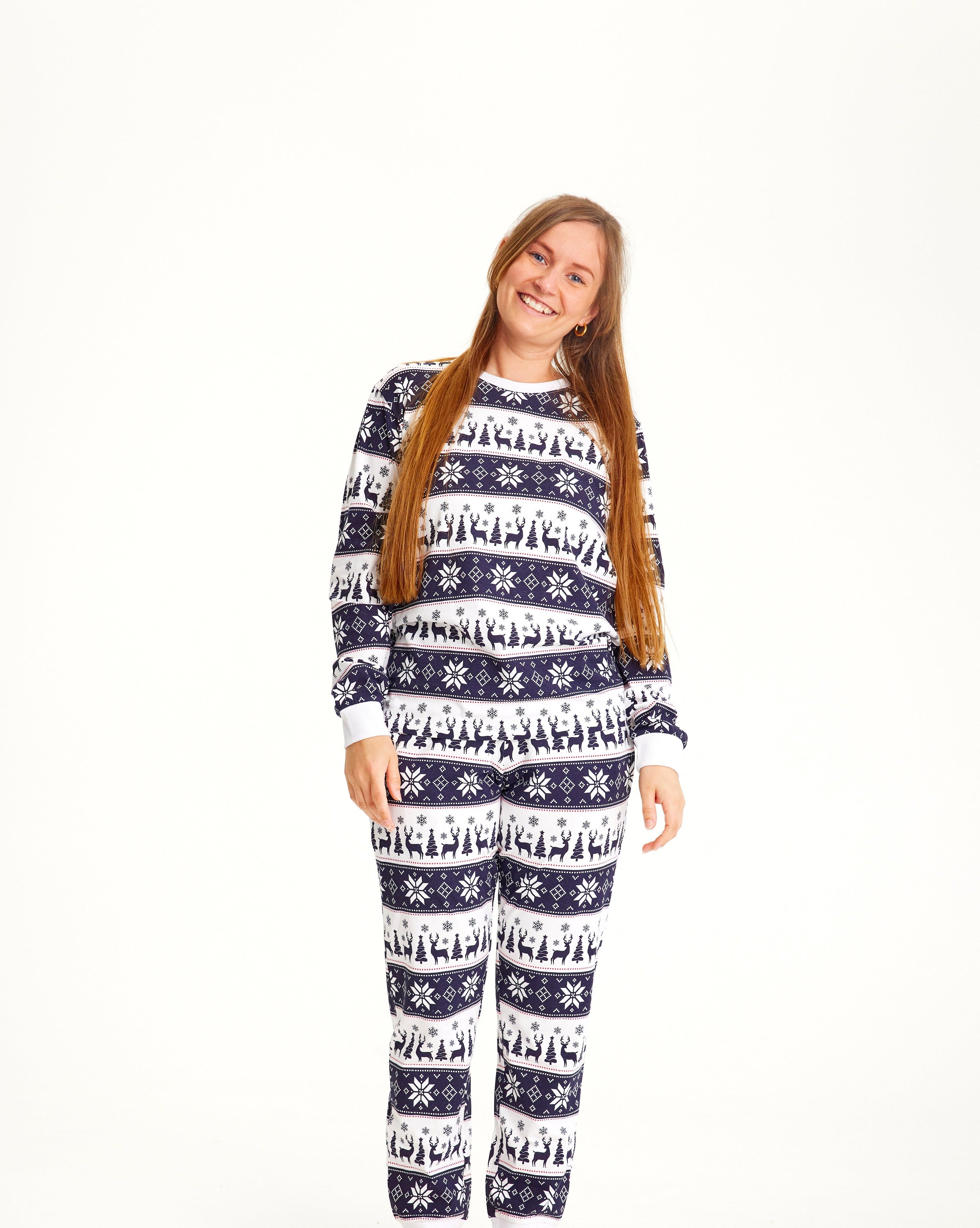 En smilende dame iført stribede julepyjamas.