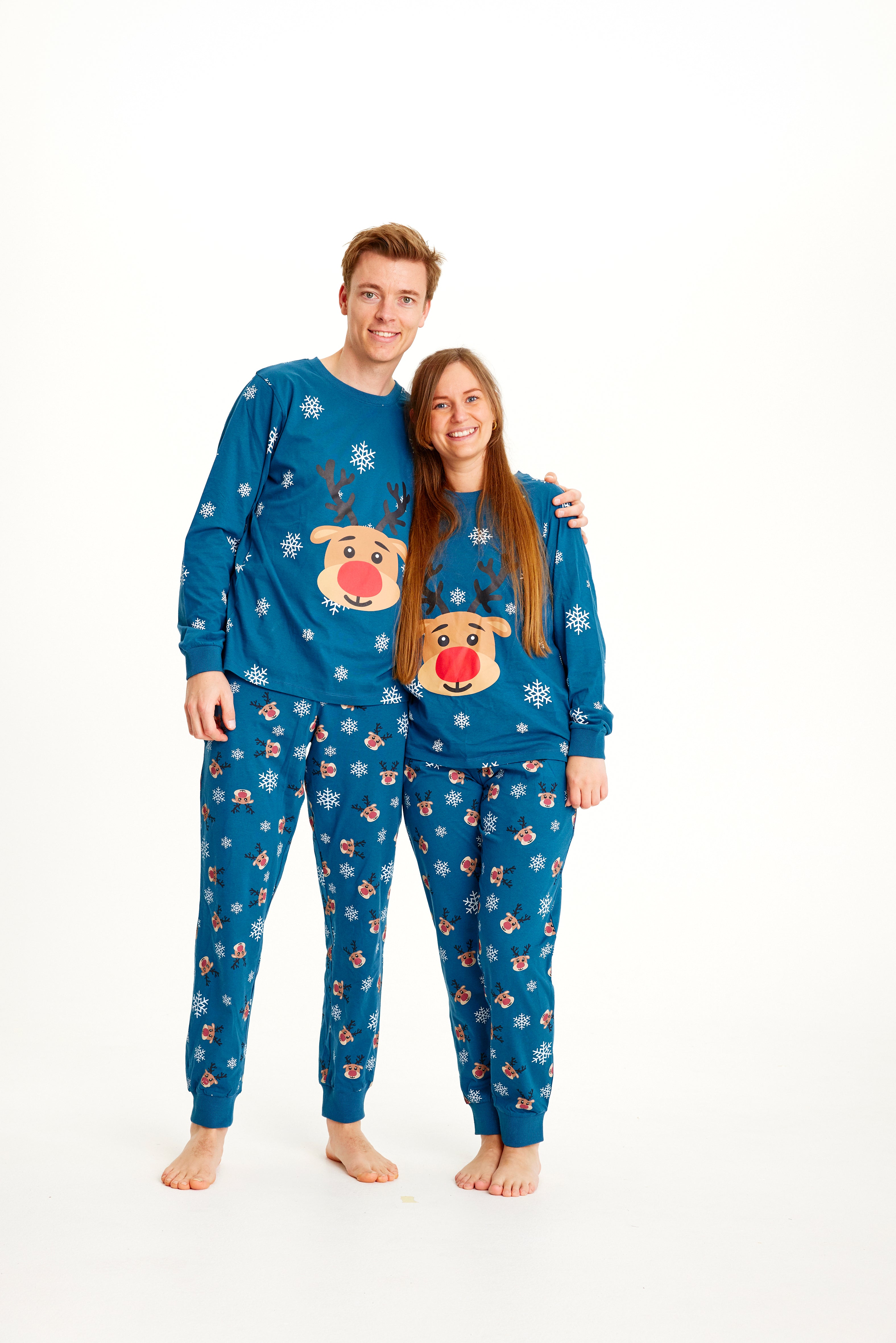 Et par holder om hinanden og er klædt i samme blå julepyjamas.