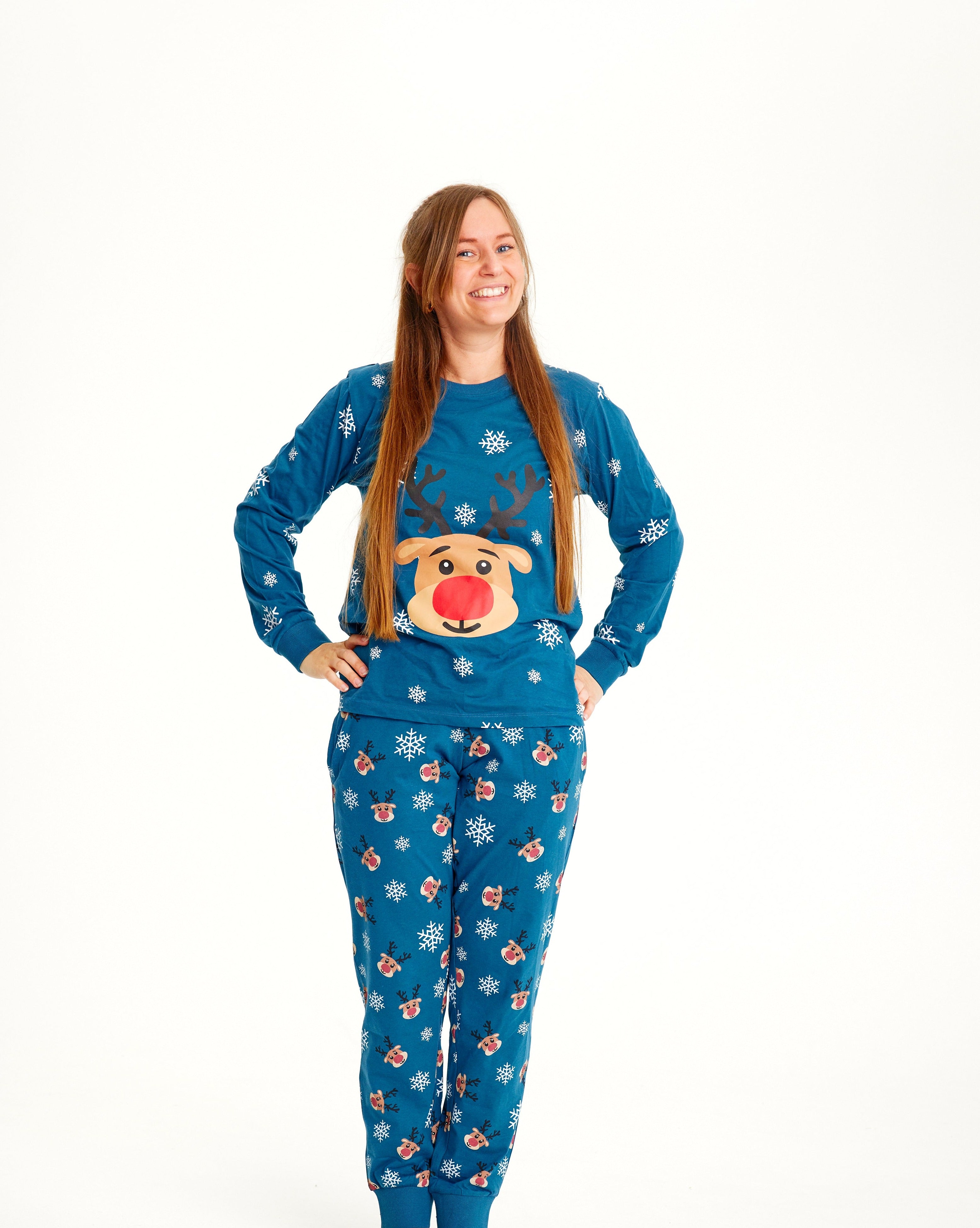 En smilende dame iført blå julepyjamas.
