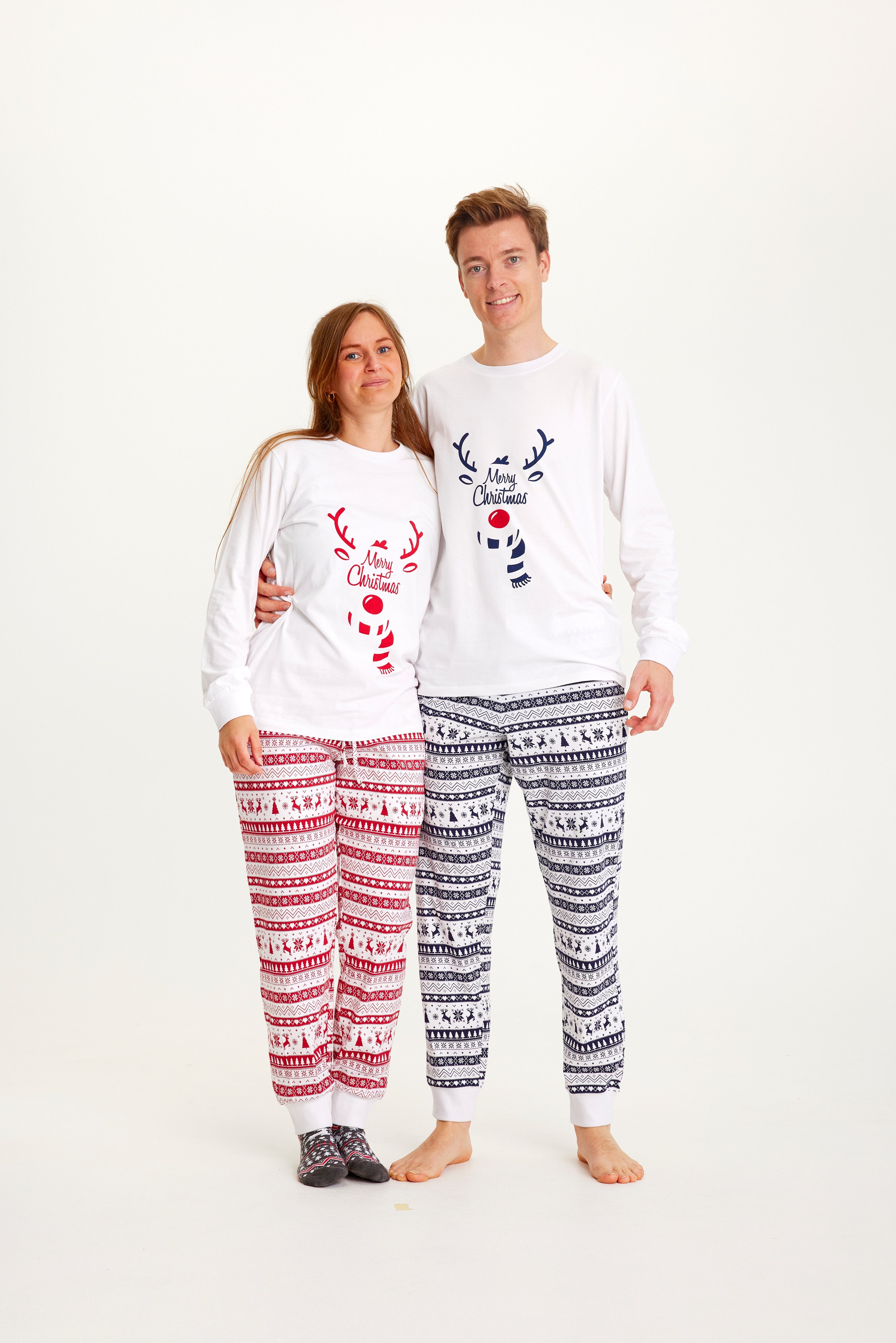 En kvinde og en mand iført hver deres julepyjamas.