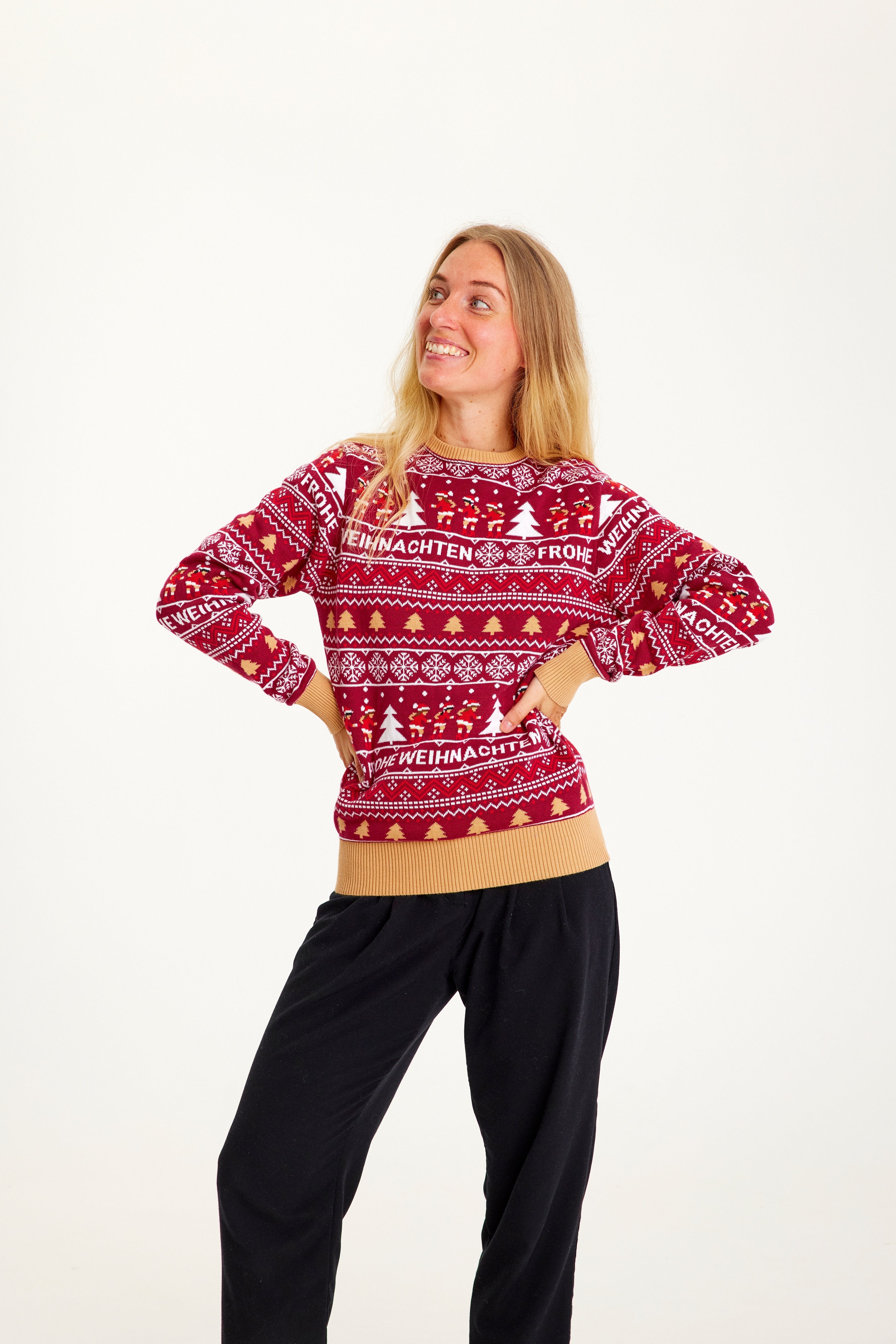 En smilende dame, der kigger til siden iført en rød julesweater.