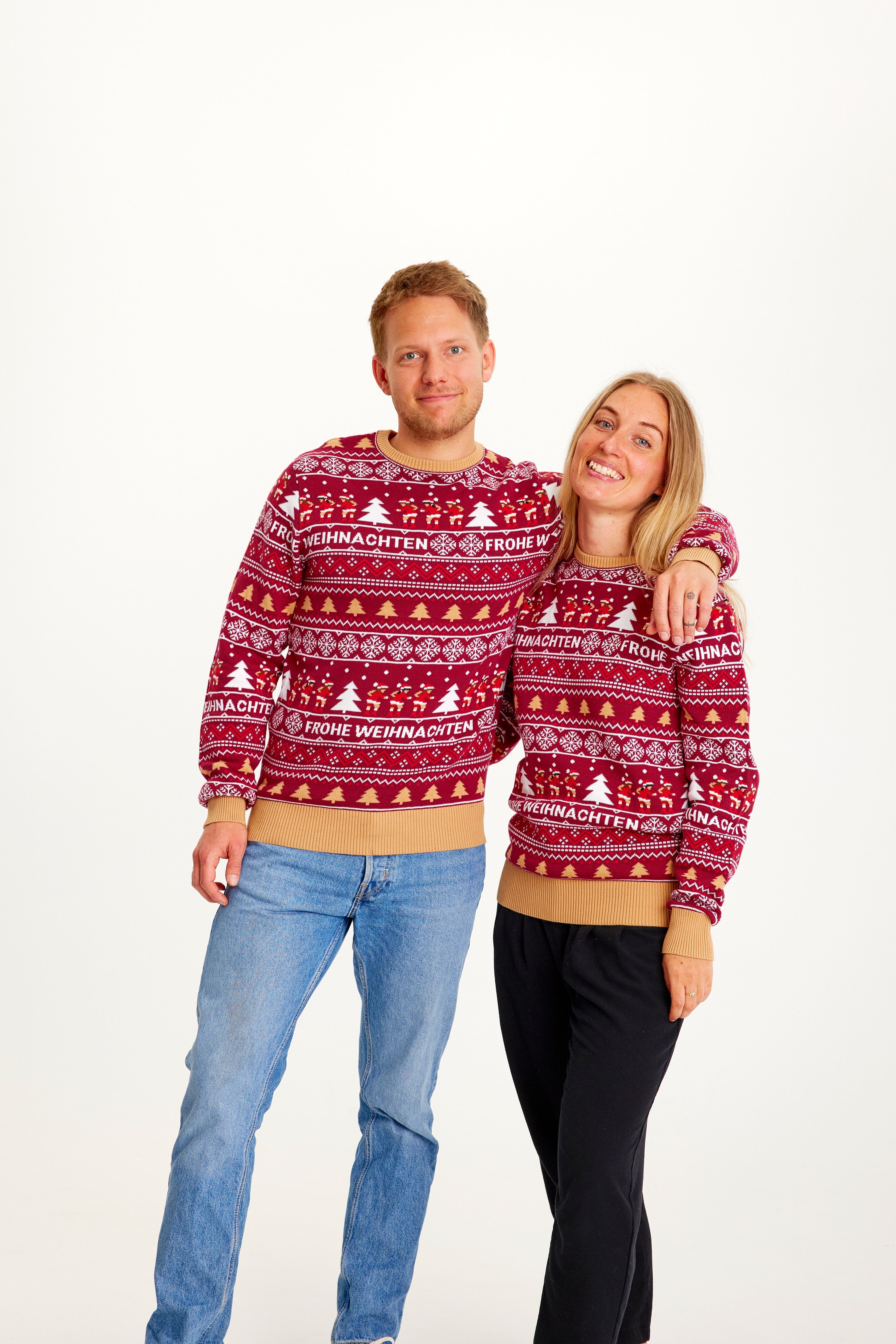 En mand og en dame iført samme røde julesweater.