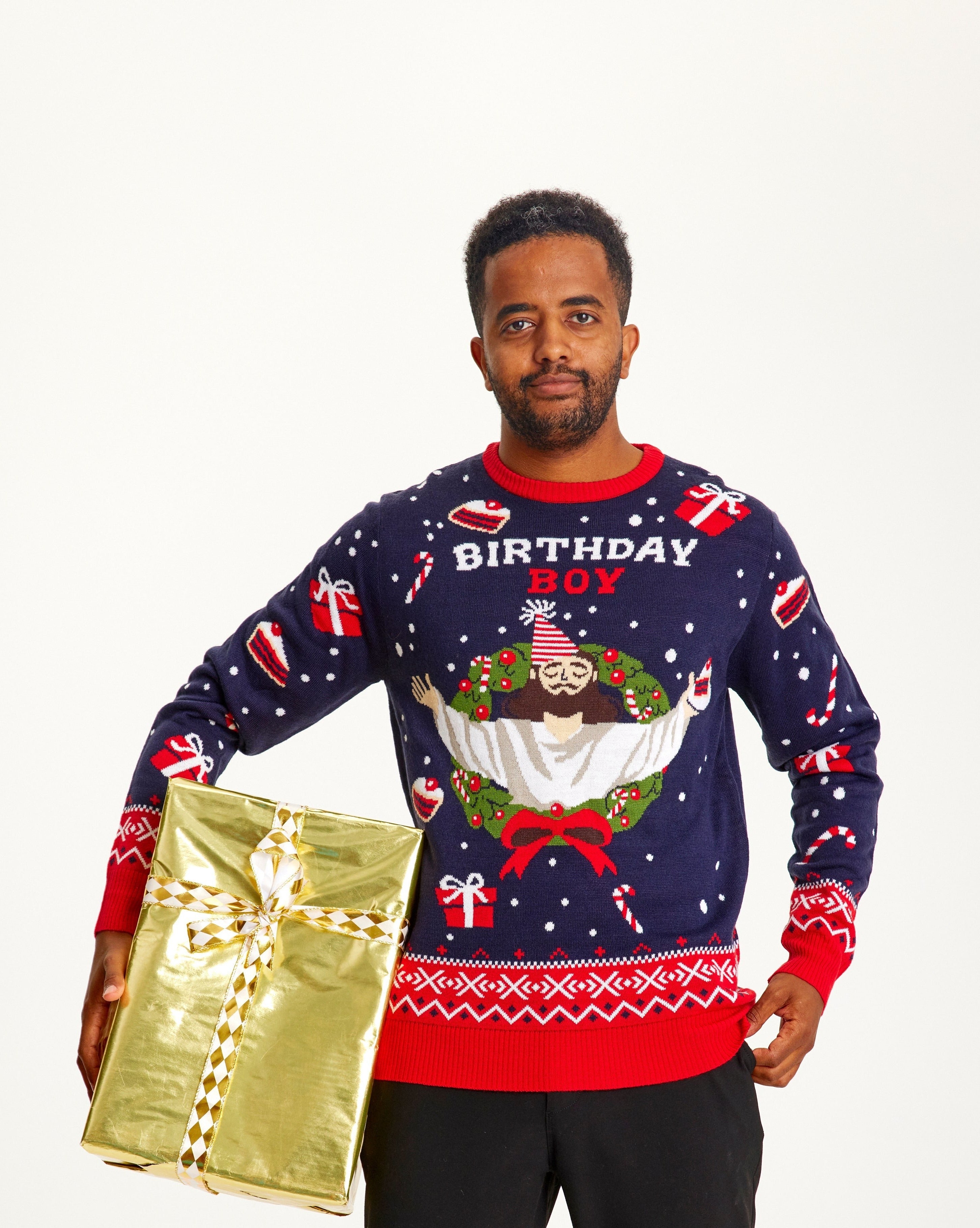 En mand iført en blå og rød julesweater med citatet 