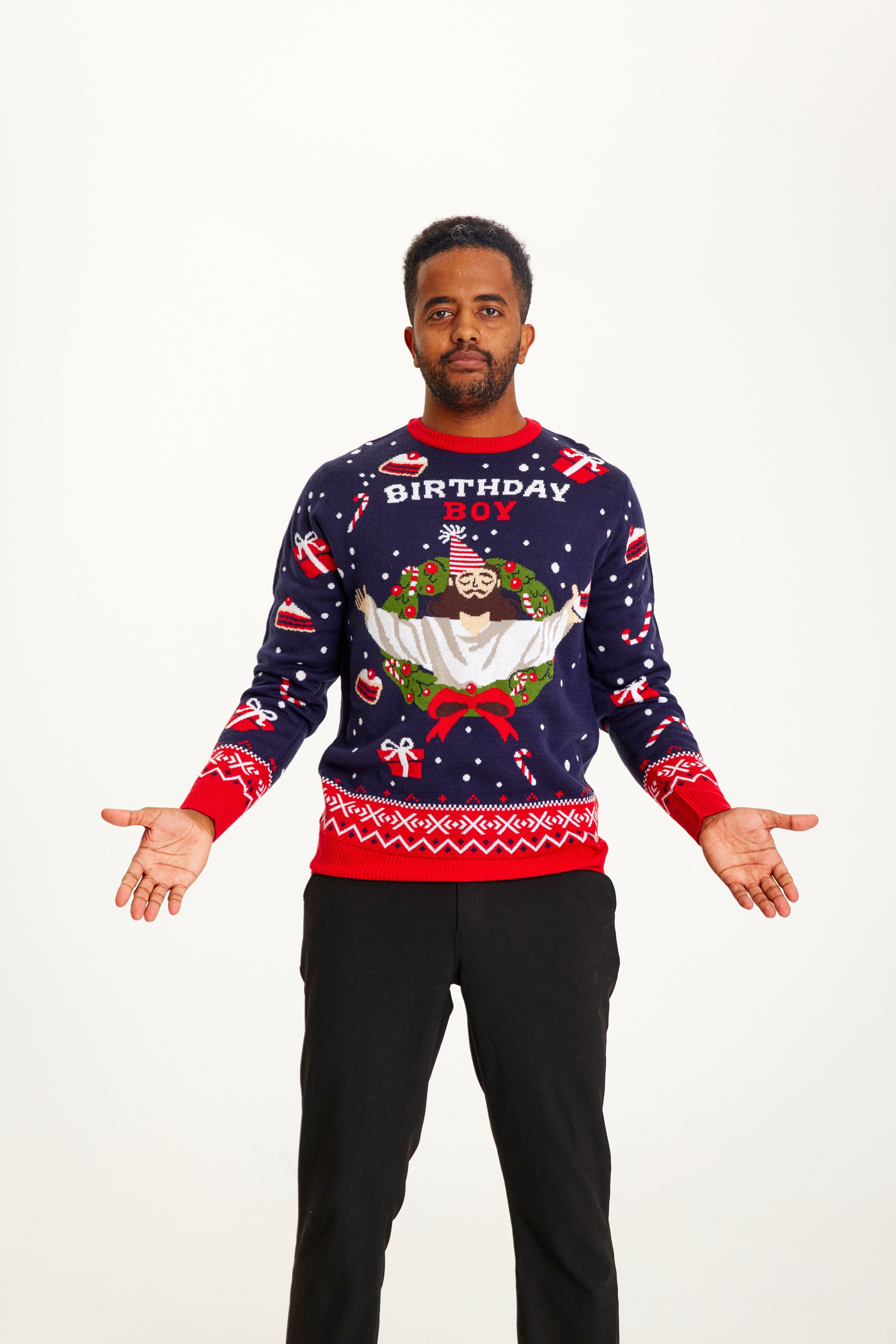 En mand med en julesweater, som har et billede af Jesus med nissehue og citatet 
