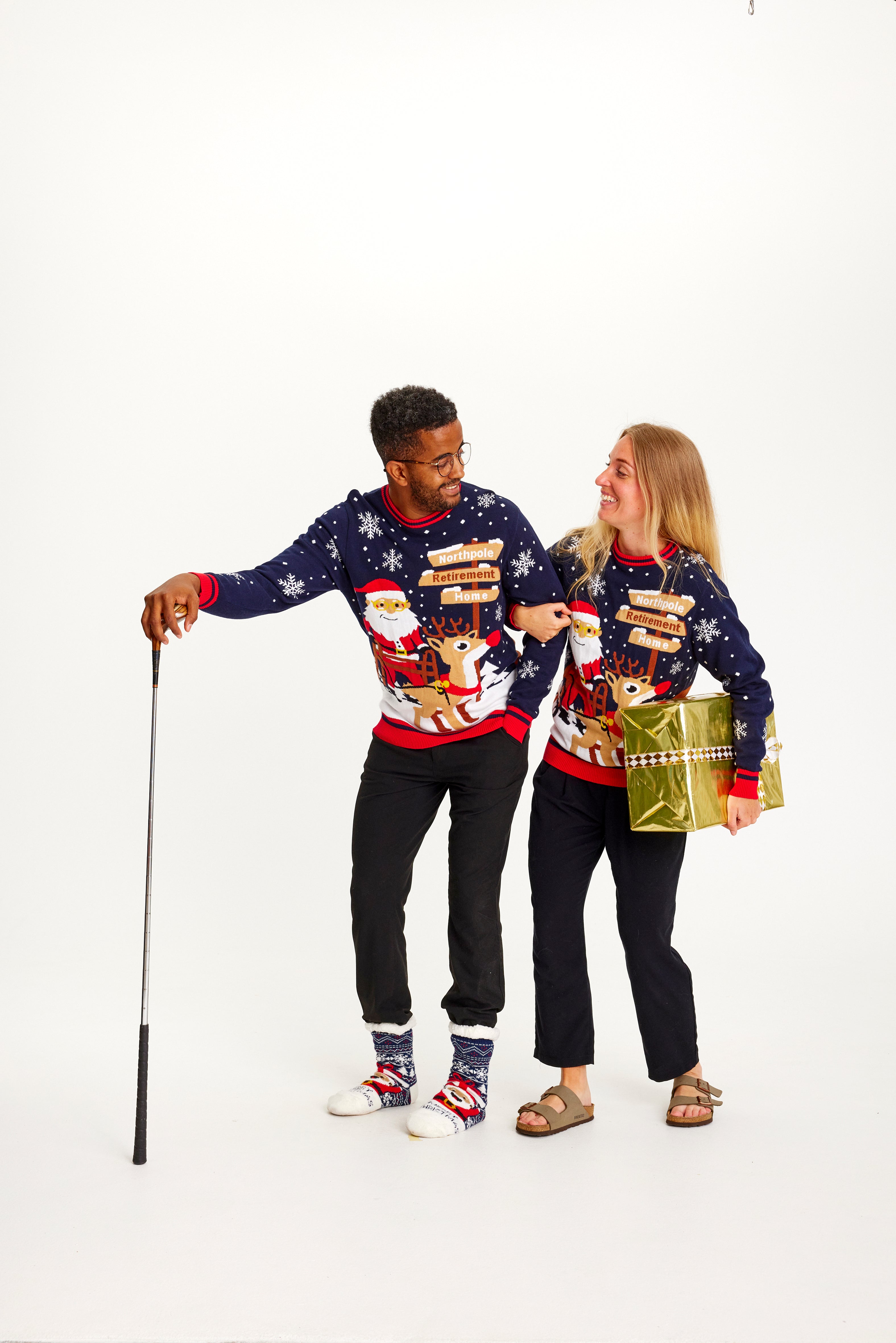 En mand og en kvinde poserer sammen i hver deres julesweater.