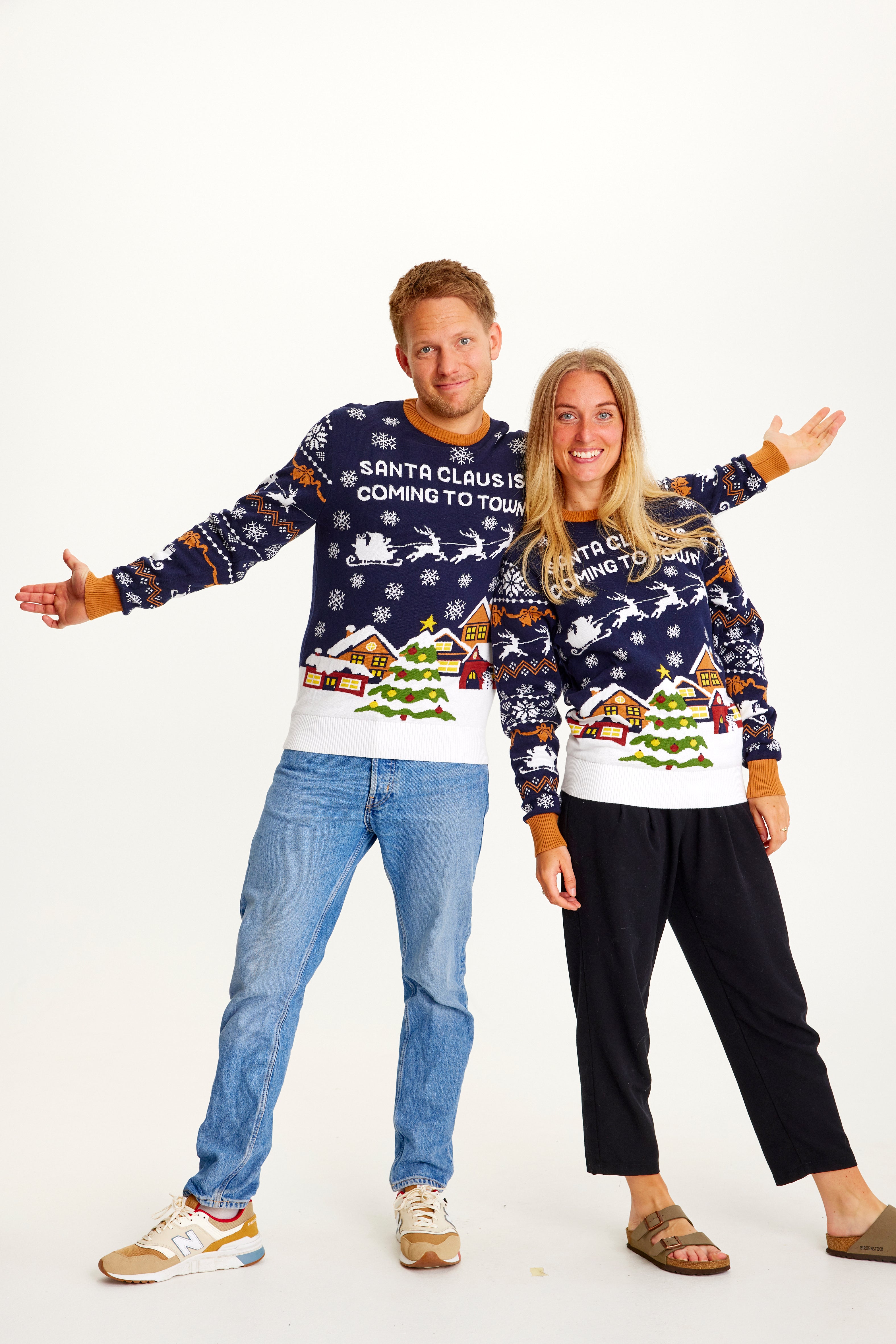 En mand og en kvinde iført samme blå julesweater.