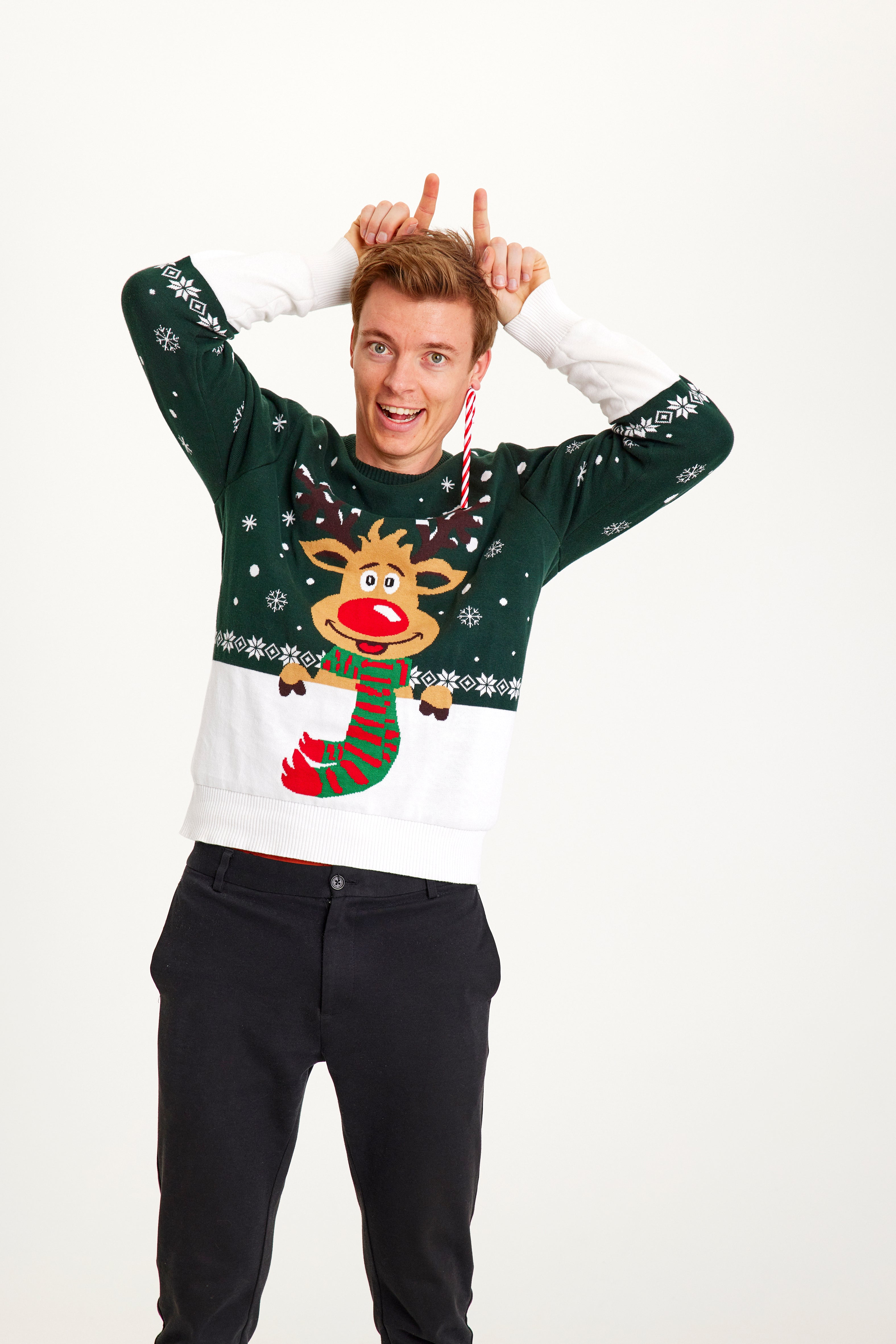 En mand iført en grøn og hvid julesweater med Rudolf med et halstørklæde på.