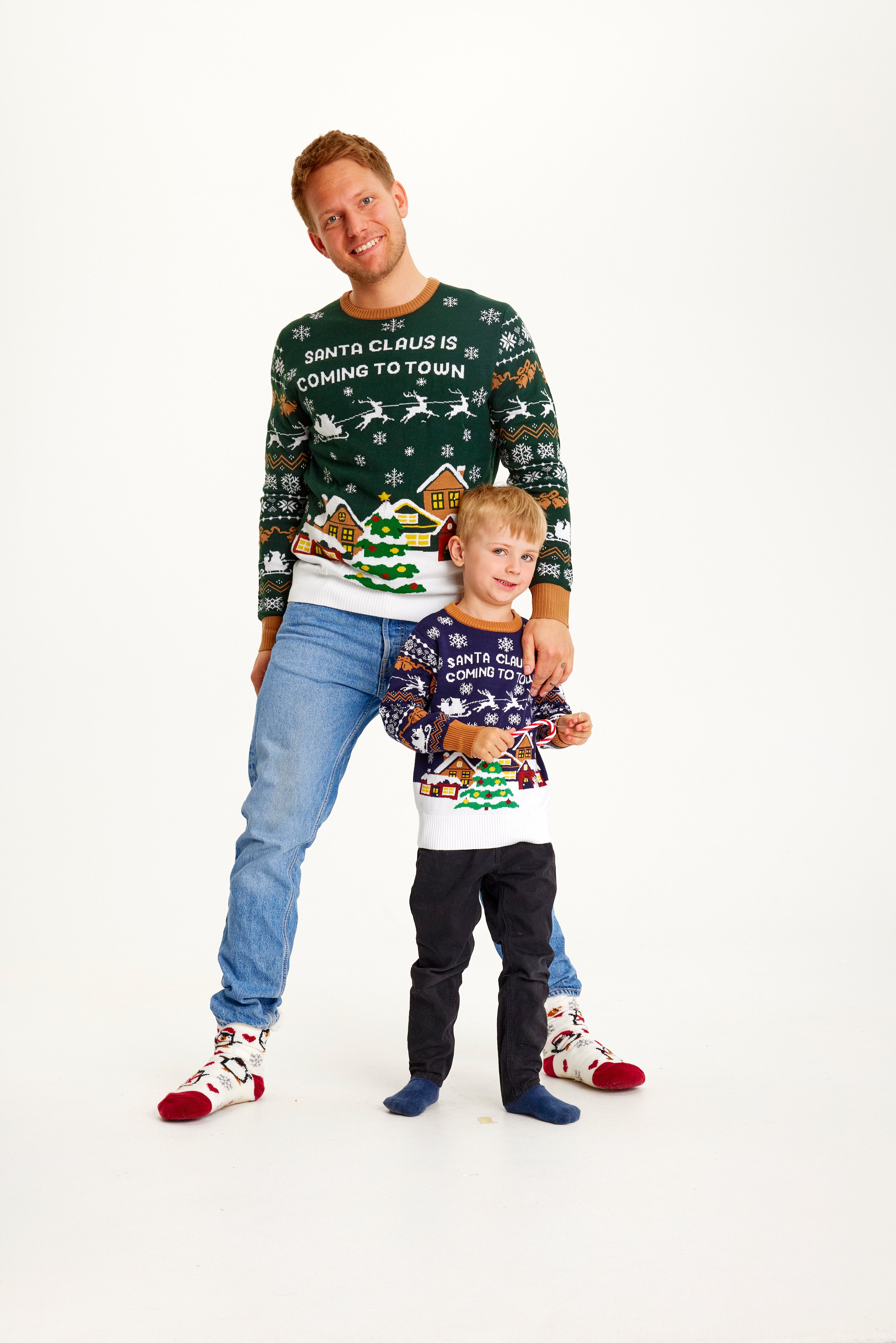 En mand og et barn iført julesweatre.