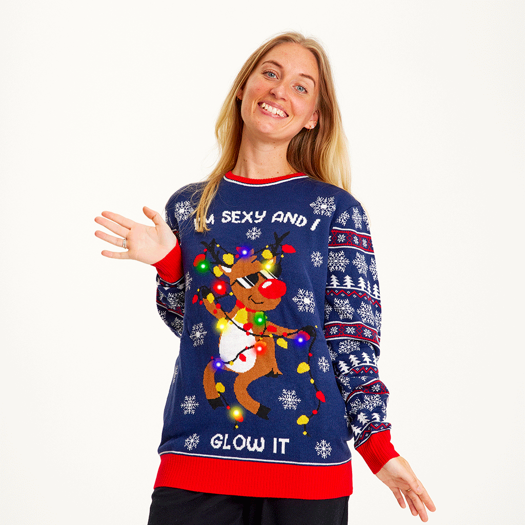 En smilende kvinde iført en flå julesweater med lys.
