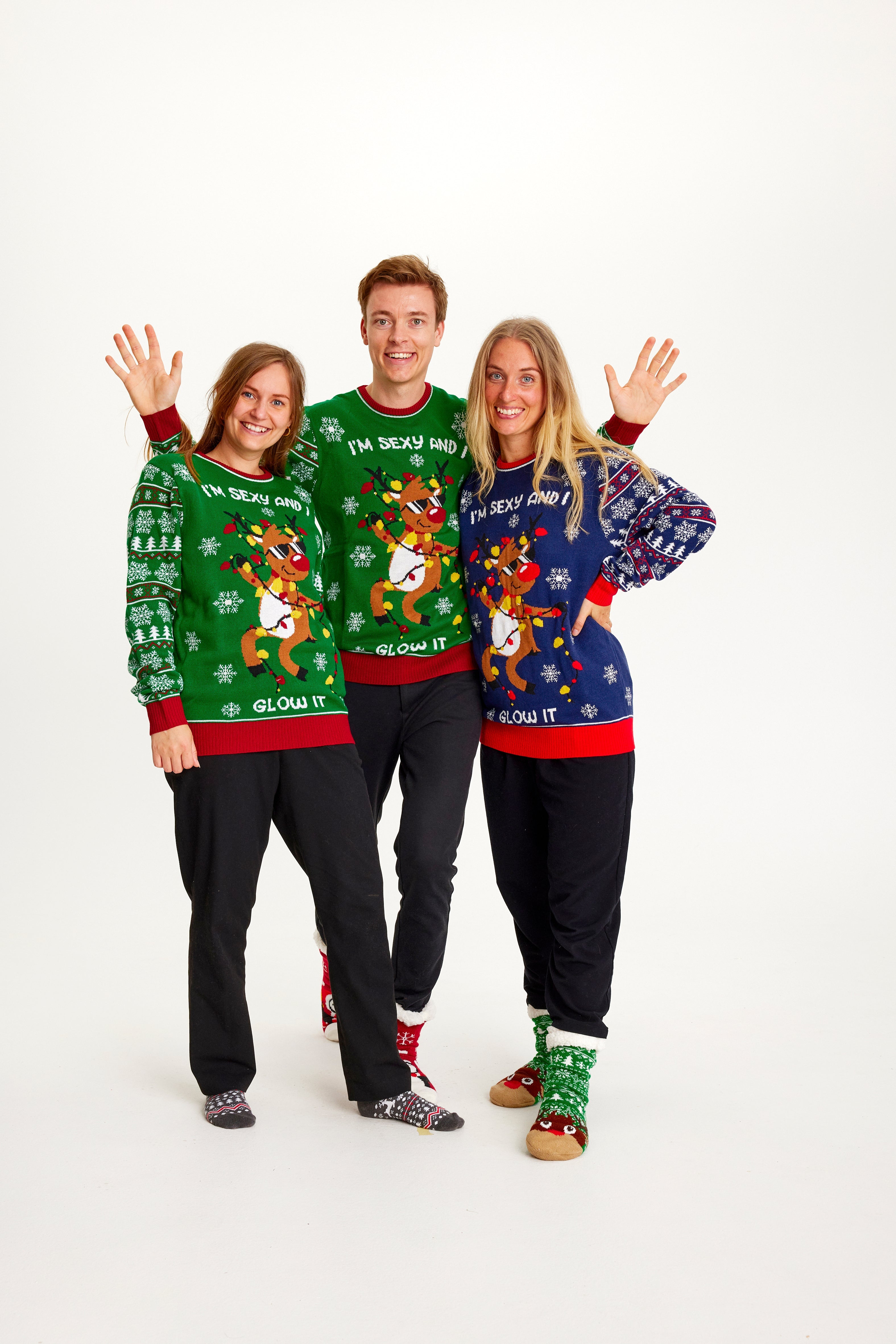 Tre person holder om hinanden og poserer i hver deres julesweater.