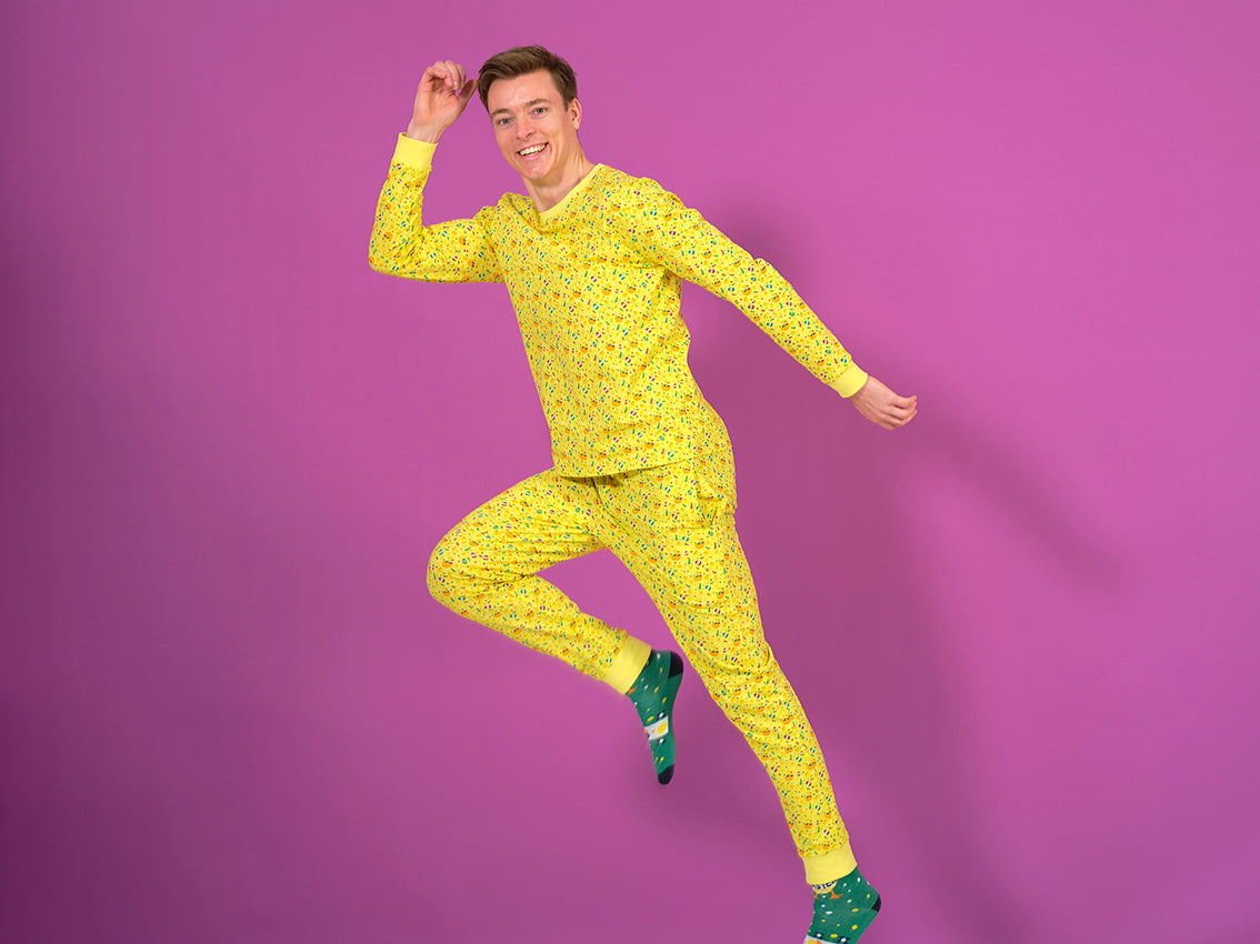 En løbende mand i en gul påskepyjamas på kyllinger på.