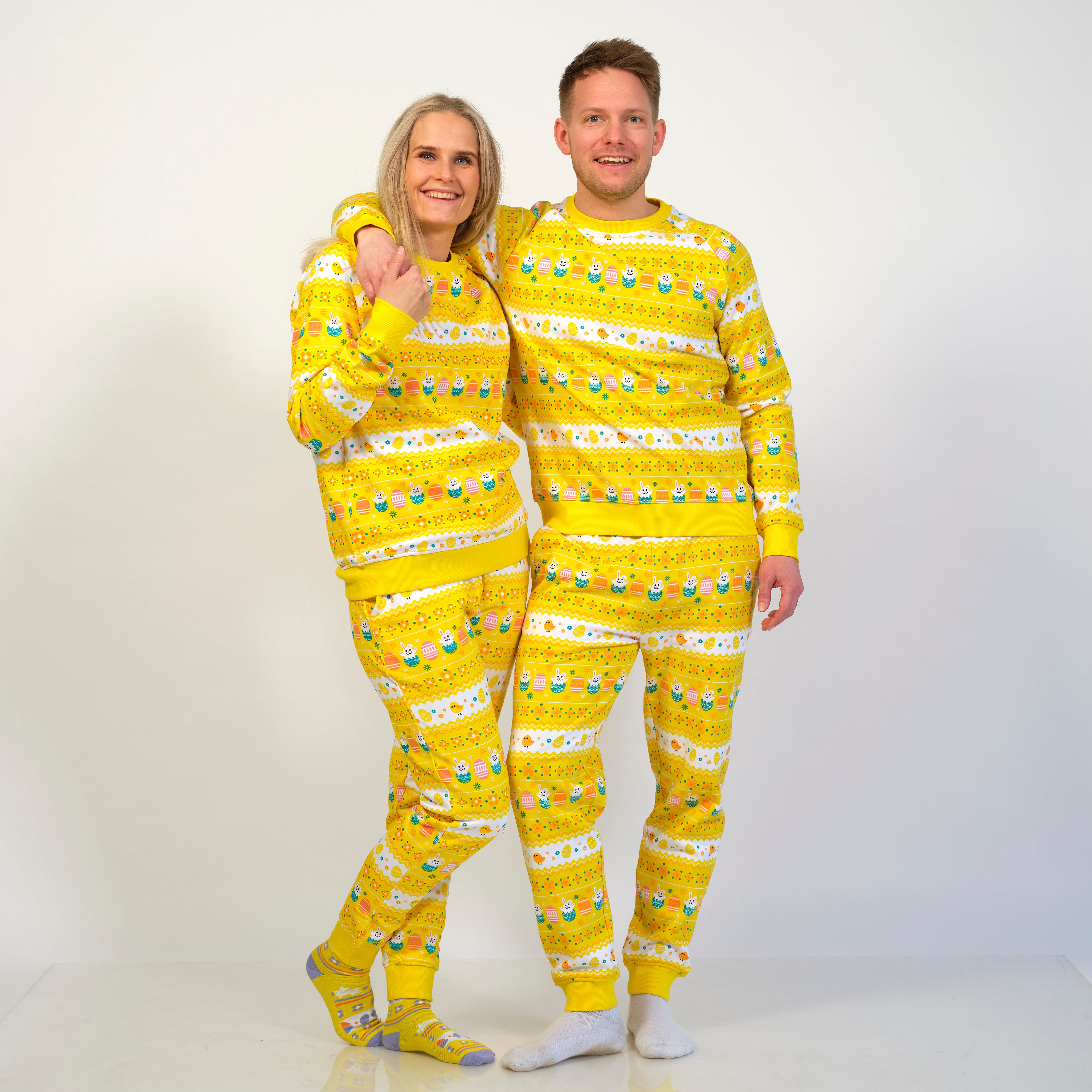 En smilende mand og dame poserer sammen i et gult påskesæt.