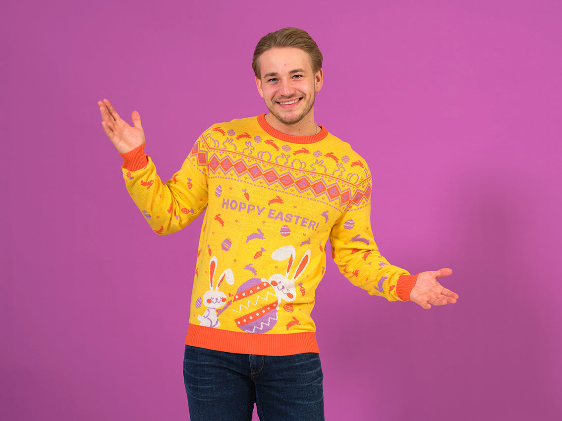 En smilende mand i gul påskesweater med påskeharer og æg.
