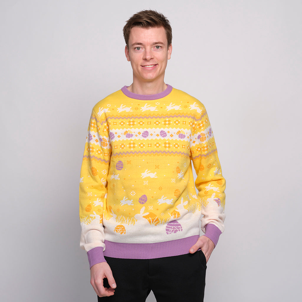 En mand står i en gul påskesweater.